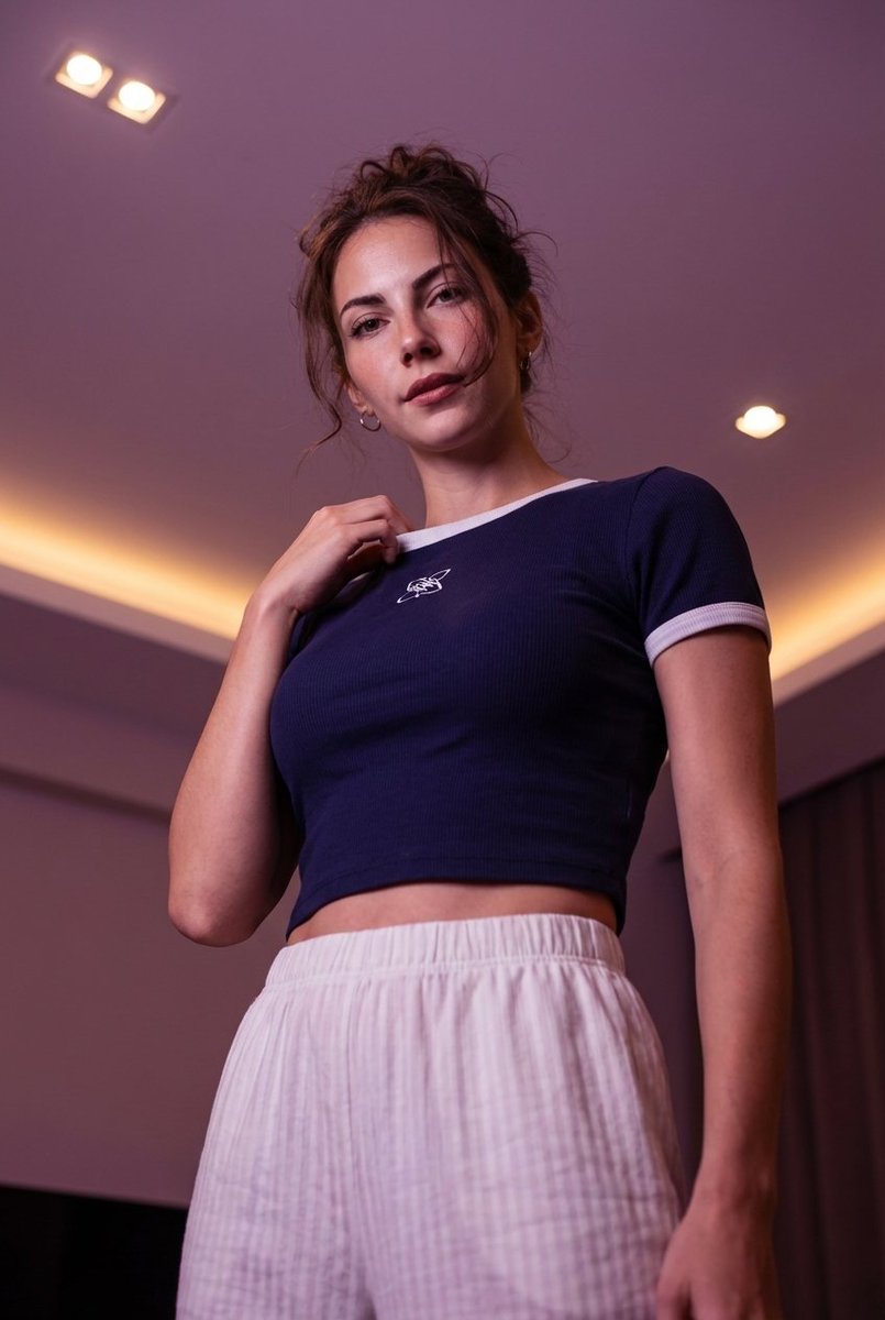 Low-angle stylized portrait of a young woman in a dim room 1